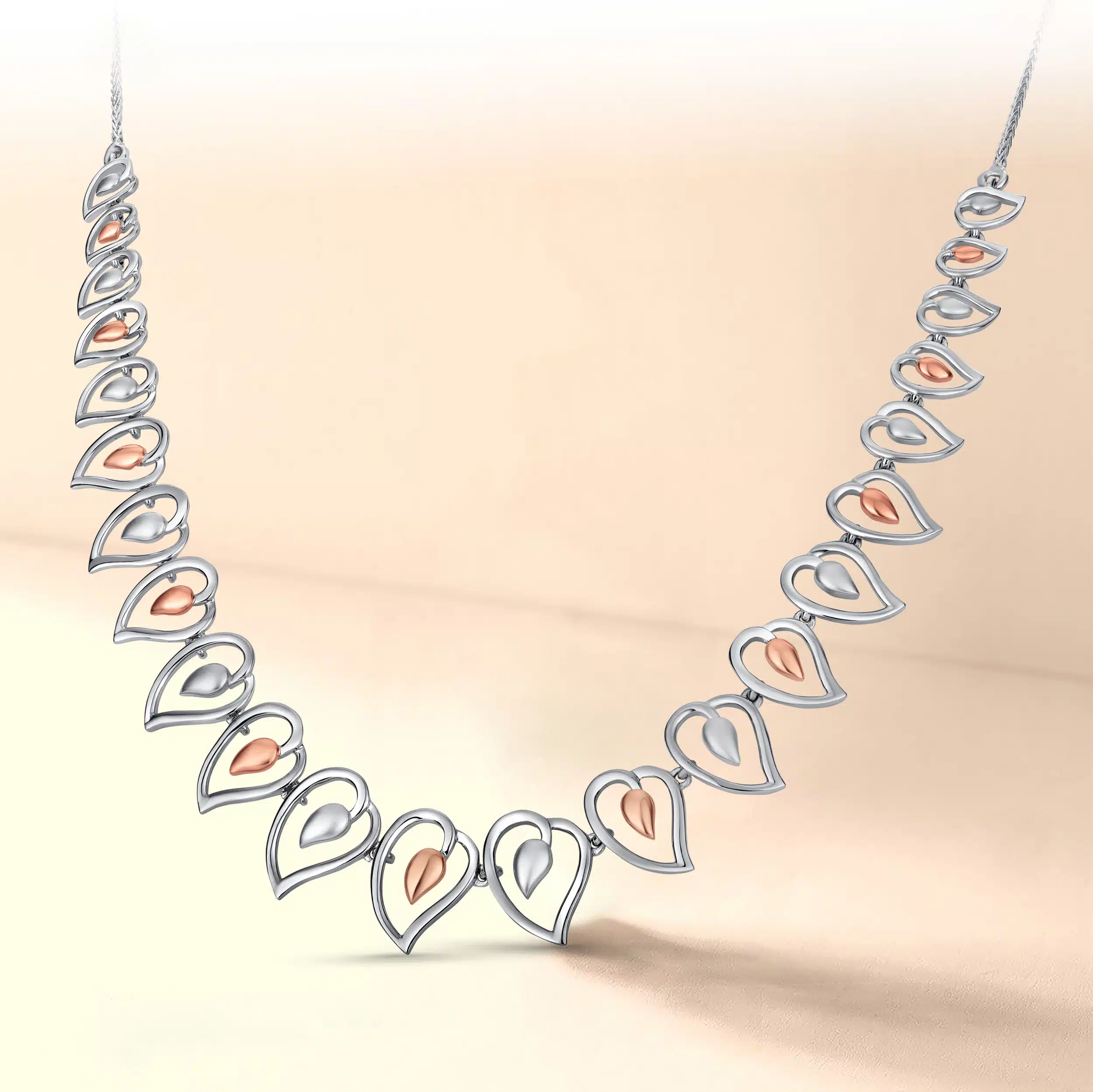 Gold and platinum mixed bridal necklace photography on a baby pink color background with creative shooting lighting