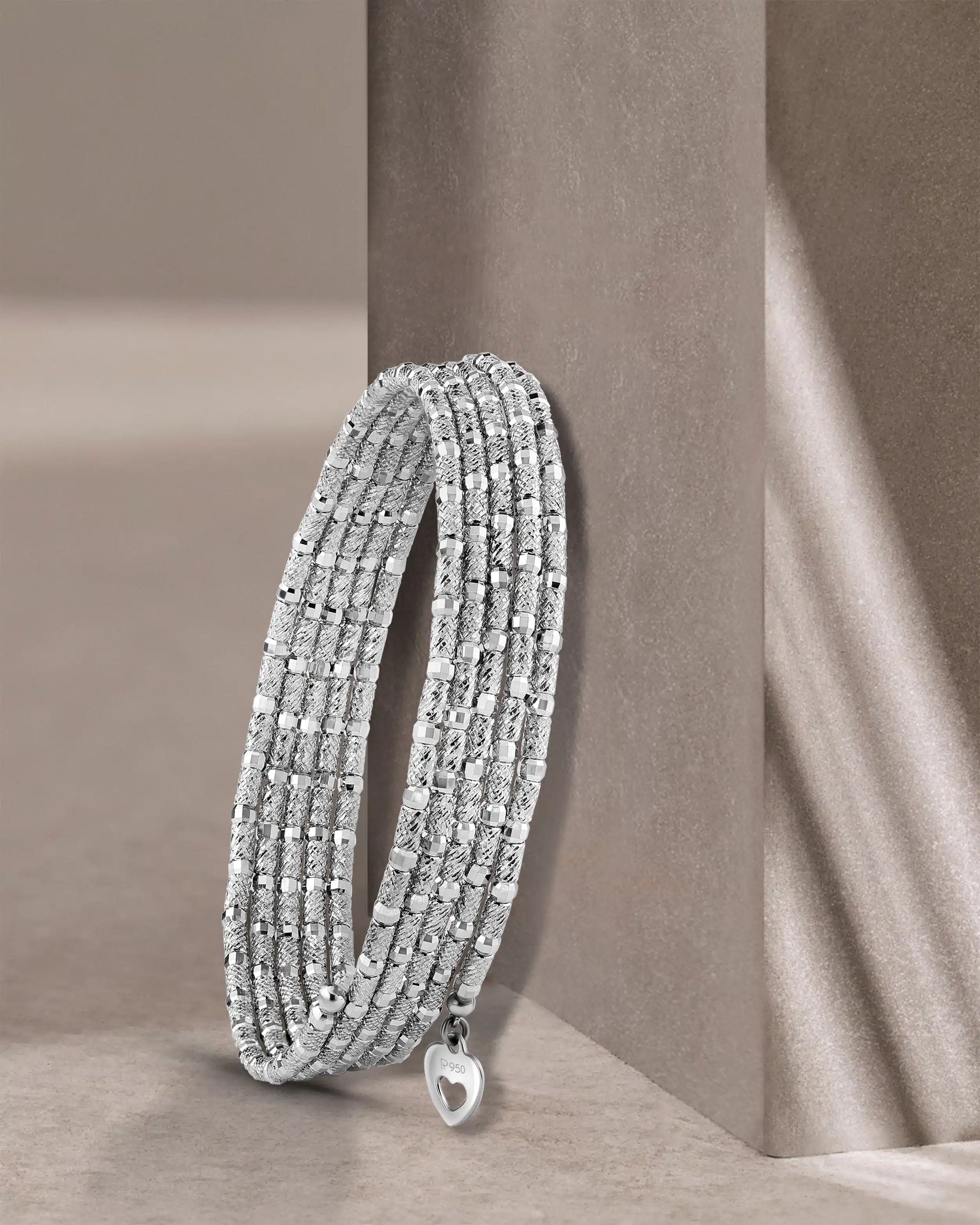 Flecible 5 row platinum bracelet creatively photographed on beige background, shot by pankaj mathur mumbai