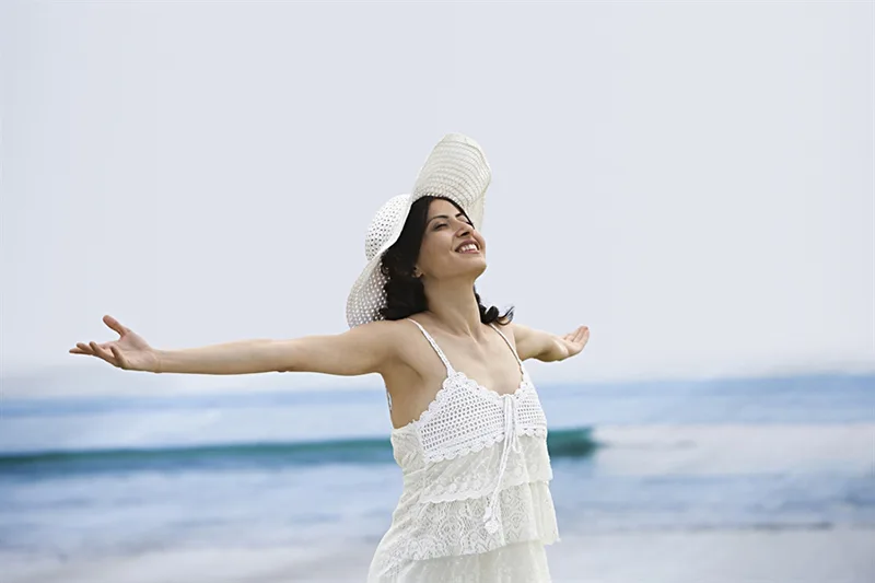 Happy female model posing for a photoshoot in an open seaside, outdoor shoot at the beach